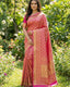 Woman wearing a pink saree with a green garden background